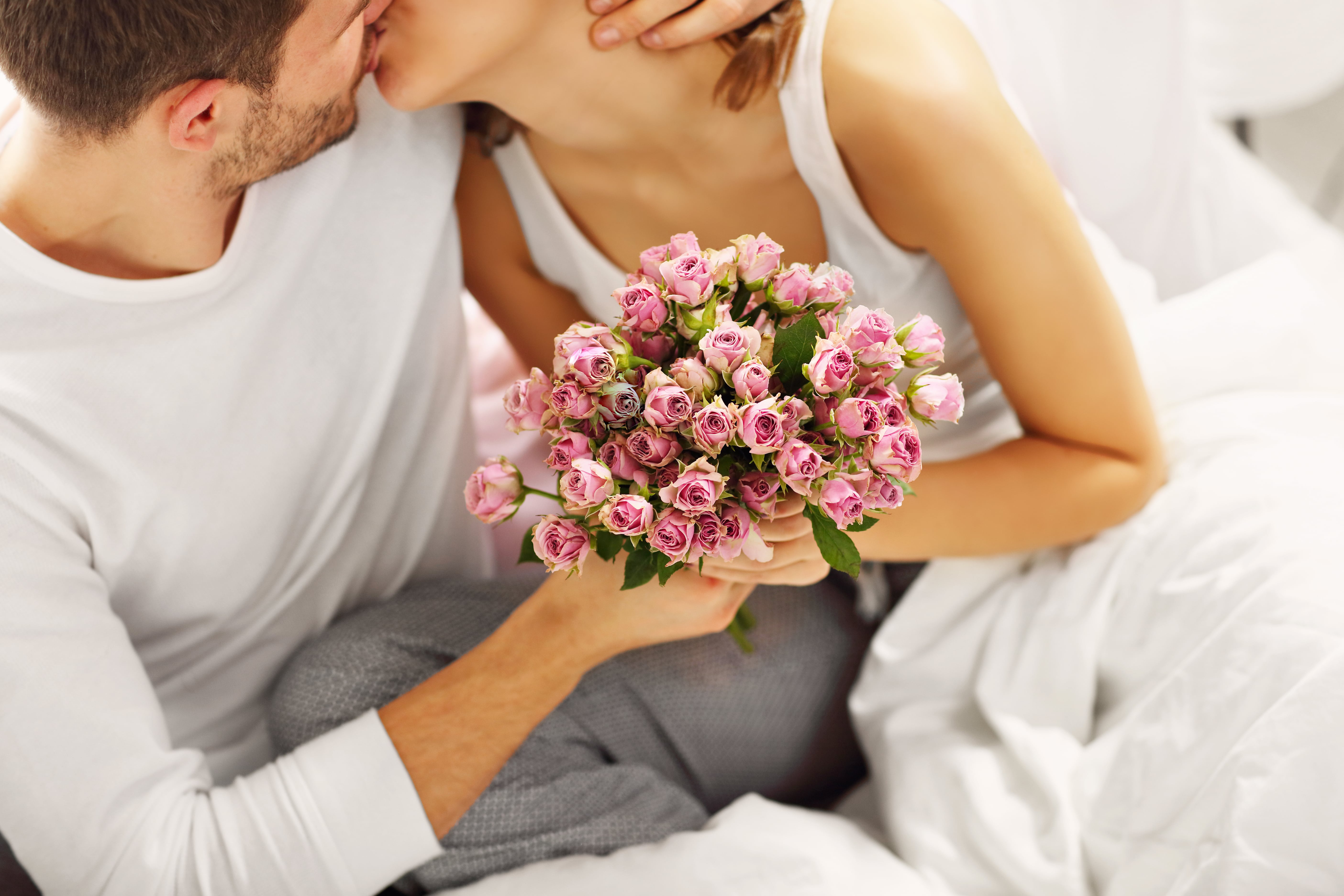 Дарит жене цветы и обнимает